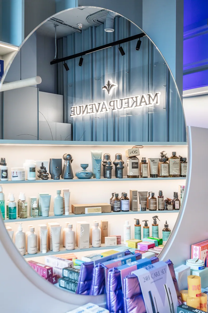 Arched Makeup Avenue fragrance display with layered illuminated shelves
