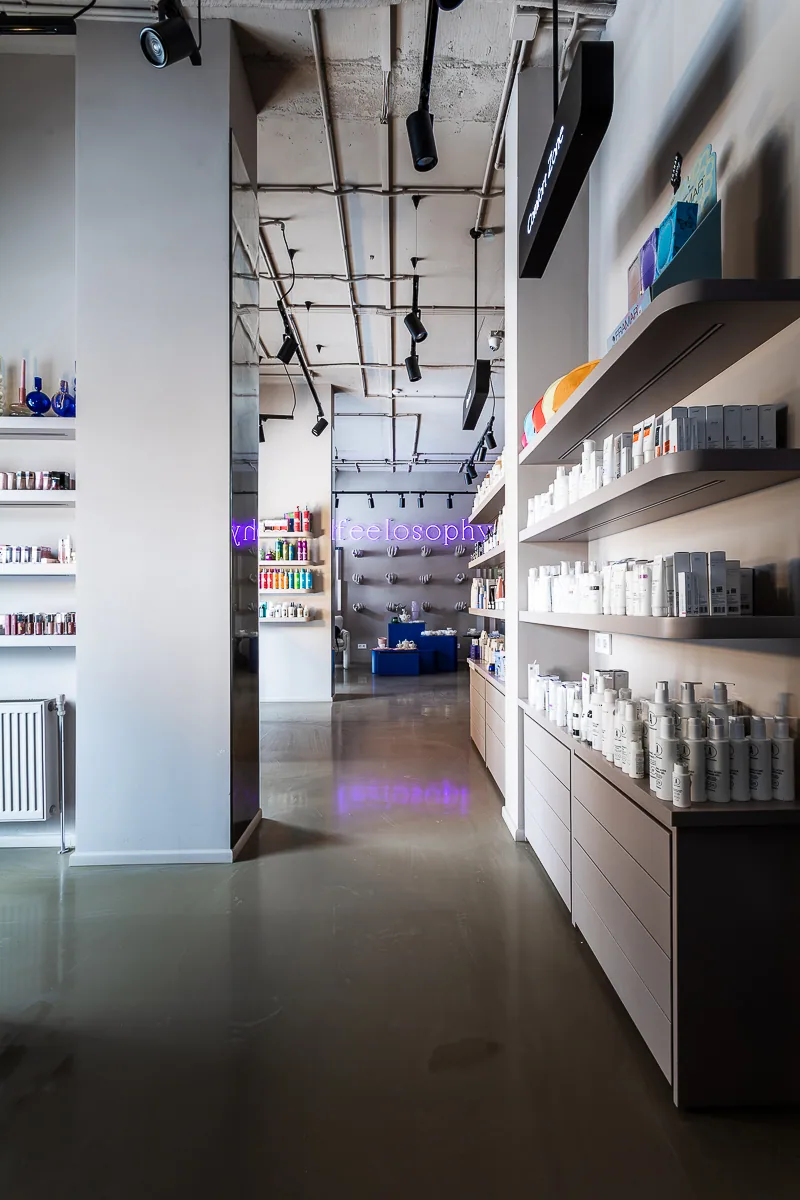 Long illuminated product shelves defining the route through Feelosophy