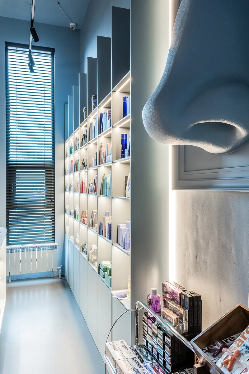 Narrow window bay framed by pale blue curved shelving