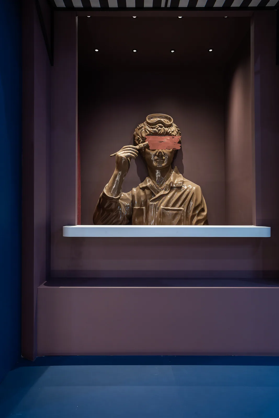 Classical figure framed in a deep burgundy niche inside the pavilion
