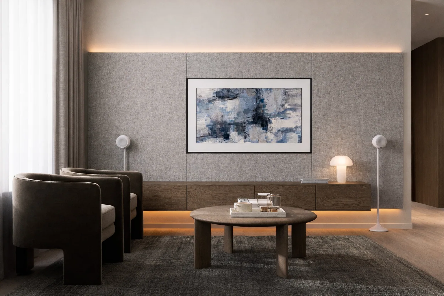 Low media console and sculptural armchairs in the softly lit living room